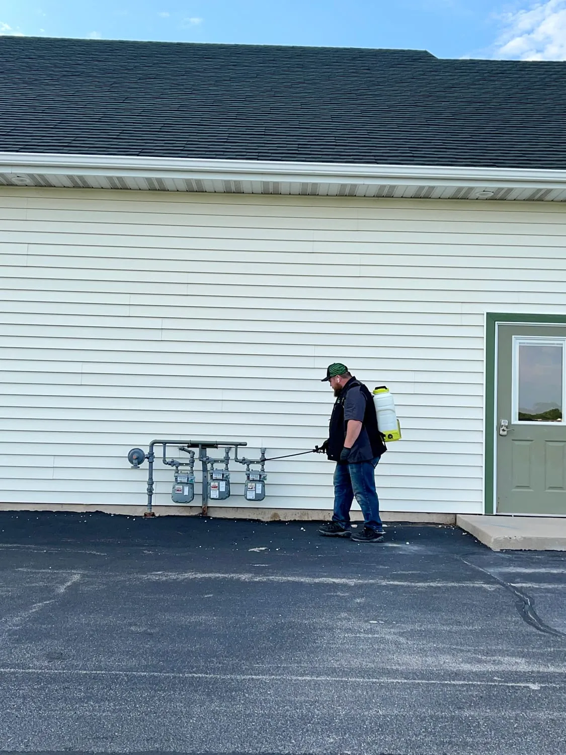 BugBoss treating the exterior walls and foundation of a home in Northeast Wisconsin