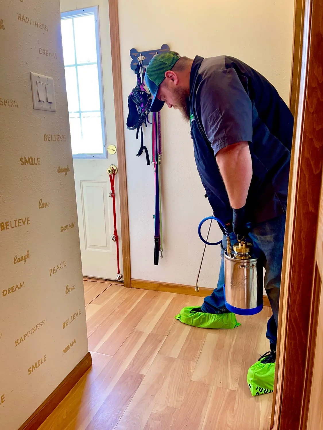 BugBoss technician wearing shoe covers while treating inside a customer's home